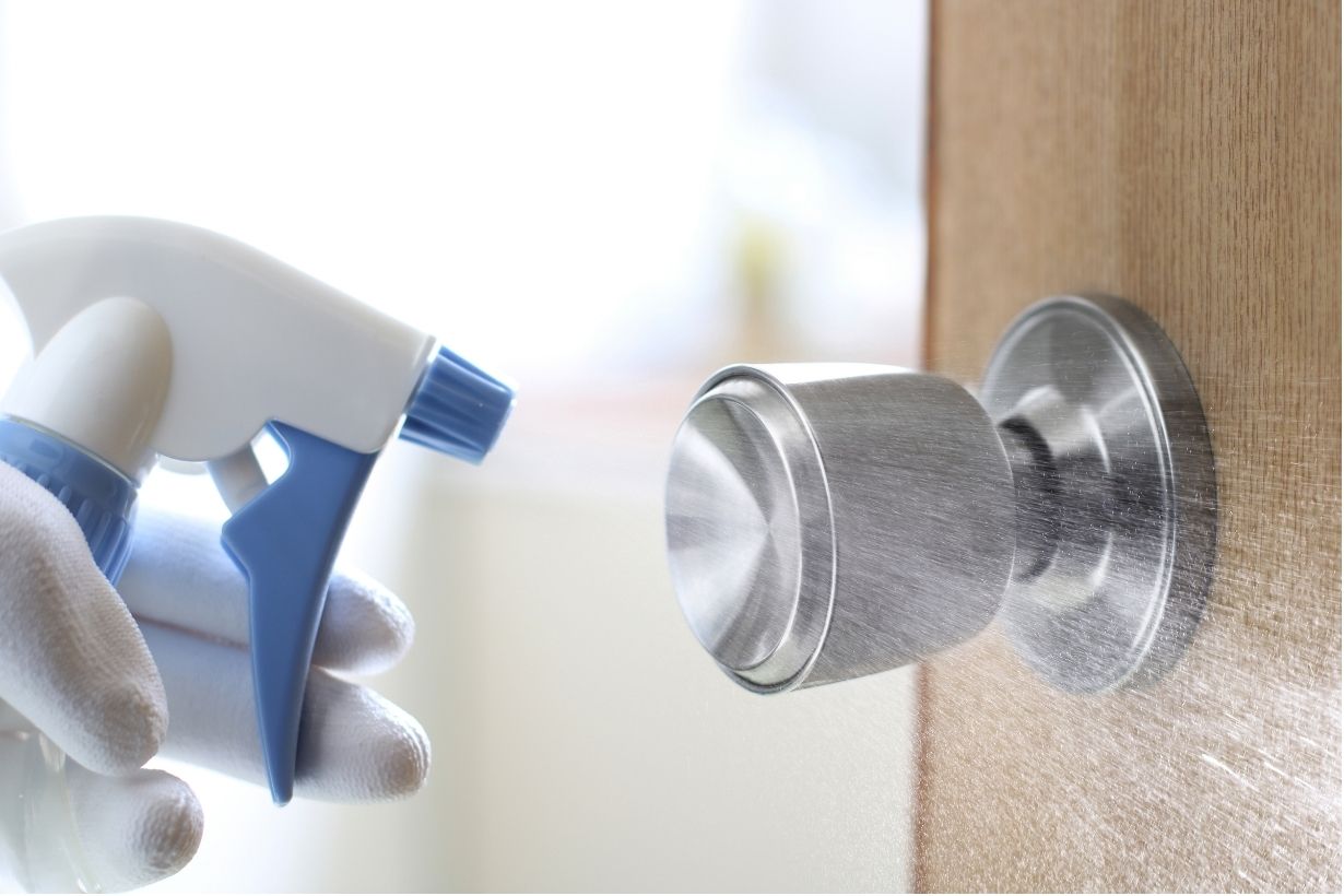 Day porter disinfecting high-touch door handles in a Vancouver office